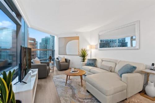 a living room with a couch and a tv at Executive Downtown Suite with Great City Views in Vancouver