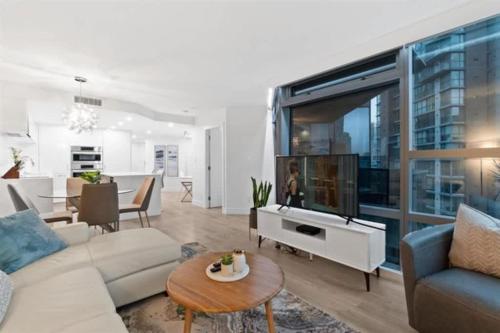 a living room with a couch and a tv at Executive Downtown Suite with Great City Views in Vancouver