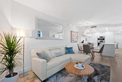 a living room with a white couch and a table at Executive Downtown Suite with Great City Views in Vancouver