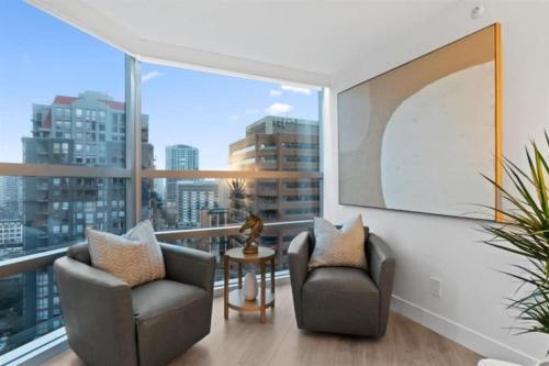 a living room with two chairs and a large window at Executive Downtown Suite with Great City Views in Vancouver