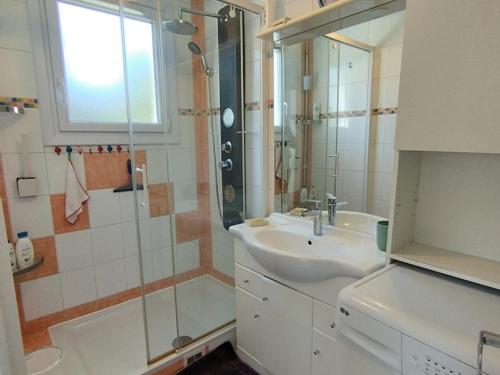 une salle de bain blanche avec un lavabo et une douche dans l'établissement T3 confortable avec terrasse et parking à 100m de la plage, pour 6 personnes à Narbonne-Plage - FR-1-795-64, à Narbonne