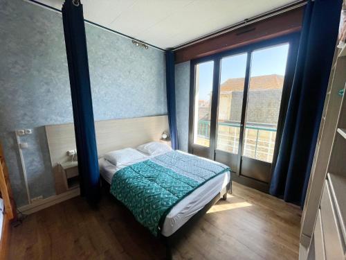 une chambre avec un lit et une grande fenêtre dans l'établissement T2 Confortable, 2 min de la Plage, Aperçu Mer, Quartier Arago - FR-1-92-572, à Les Sables-dʼOlonne