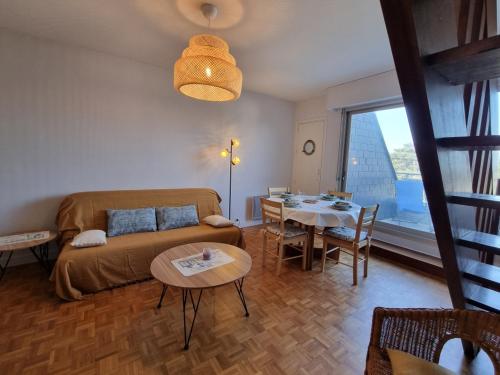 un salon avec un canapé et une table ainsi qu'une salle à manger dans l'établissement Appartement T3 près plage, parking, animaux admis, 4 personnes - FR-1-775-23, à Sarzeau