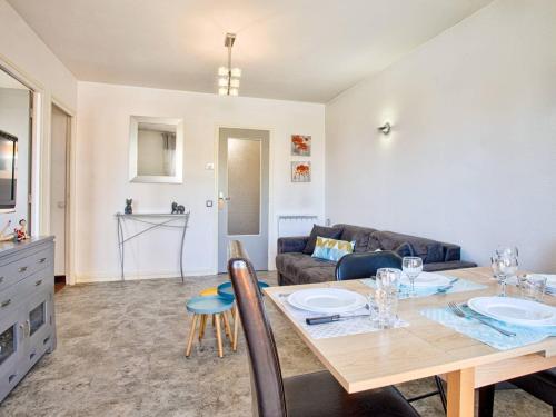 un salon avec une table et un canapé dans l'établissement Charmant 2 pièces avec balcon, vue mer et parking - FR-1-788-68, à Cabourg