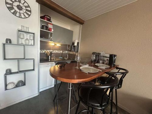 une cuisine avec une table, des chaises et une horloge dans l'établissement Appartement 2 pièces ensoleillé, vue sur port, proche plage - Cap d'Agde - FR-1-249-437, au Cap d'Agde