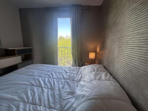 une chambre avec un lit blanc et une fenêtre dans l'établissement Appartement 2 pièces ensoleillé, vue sur port, proche plage - Cap d'Agde - FR-1-249-437, au Cap d'Agde