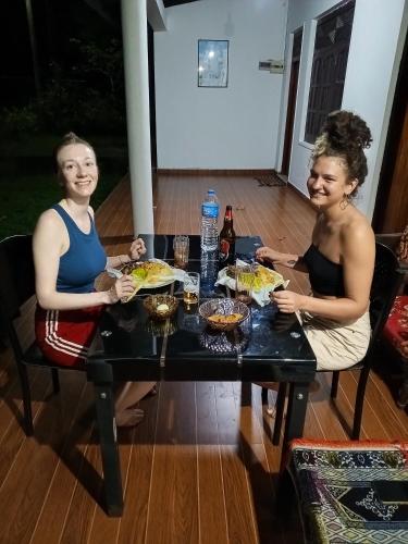 two women sitting at a table eating food at Deer Garden Guest in Polonnaruwa