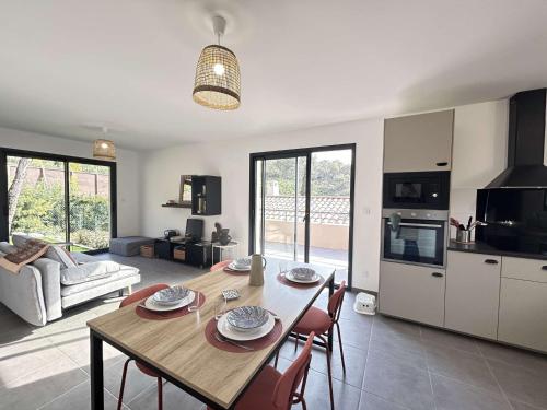 une cuisine et un salon avec une table et des chaises dans l'établissement Maison neuve 3 pièces avec terrasse à Grimaud - FR-1-226-558, à Grimaud