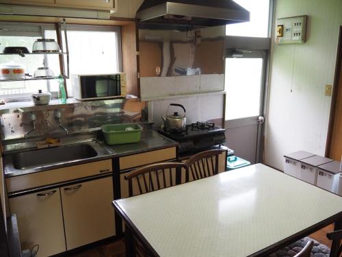 a kitchen with a sink and a table with chairs at Karadake Hills in Hanno