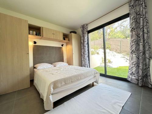 une chambre avec un lit et une grande fenêtre dans l'établissement Maison neuve 3 pièces avec terrasse à Grimaud - FR-1-226-558, à Grimaud