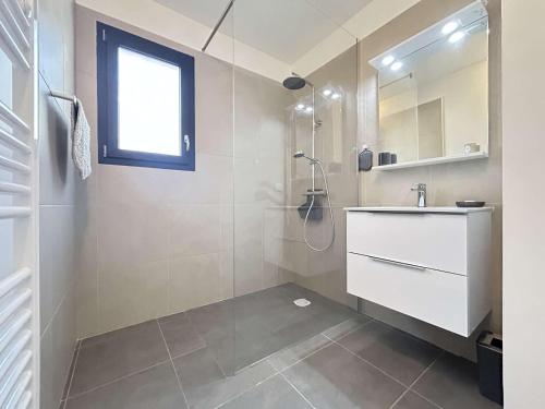 une salle de bain blanche avec un lavabo et une douche dans l'établissement Maison neuve 3 pièces avec terrasse à Grimaud - FR-1-226-558, à Grimaud