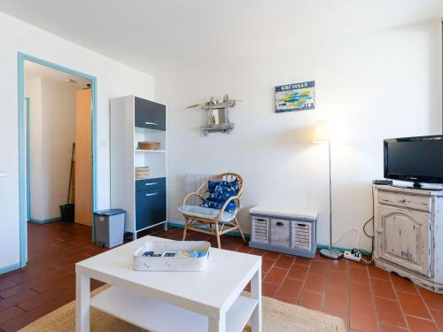 - un salon avec une table blanche et une chaise dans l'établissement Studio cabine 4 pers avec loggia à Gruissan - FR-1-409-281, à Gruissan