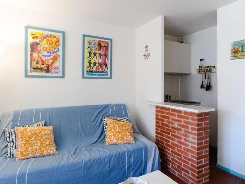 - un salon avec un canapé bleu et une cheminée en briques dans l'établissement Studio cabine 4 pers avec loggia à Gruissan - FR-1-409-281, à Gruissan