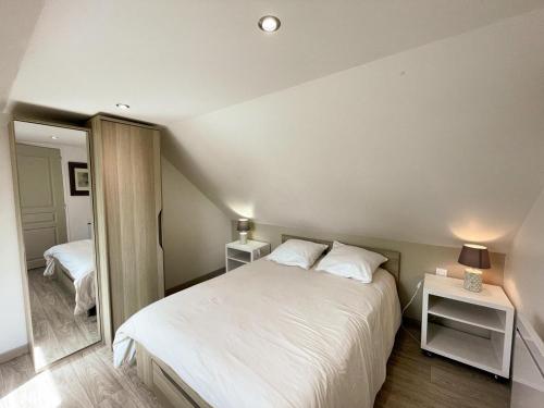 une chambre avec un grand lit blanc et un miroir dans l'établissement Charmant gîte à Chailles près de Blois avec jardin et WIFI - FR-1-491-468, à Chailles