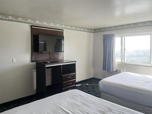 a hotel room with two beds and a flat screen tv at Oceanside, CA – Marina / Camp Pendleton in Oceanside