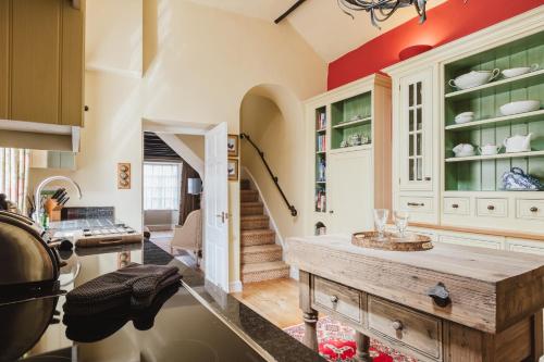 eine Küche mit einem Holztisch in einem Zimmer in der Unterkunft Hicks House - Beautiful Cottage in Leysbourne! in Chipping Campden