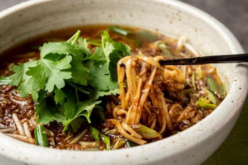 a bowl of soup with noodles and greens at Cityroute Hotel in Osaka