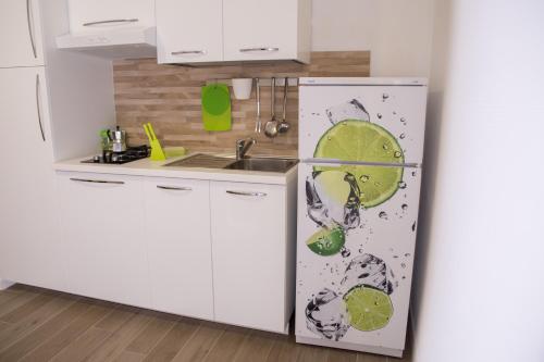 a kitchen with a refrigerator with stickers on it at Baia Del Sole in Licata