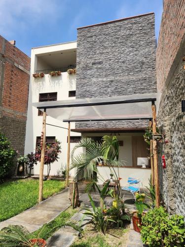 a house with a gray roof and a courtyard at China Chancay Hotel in Chancay