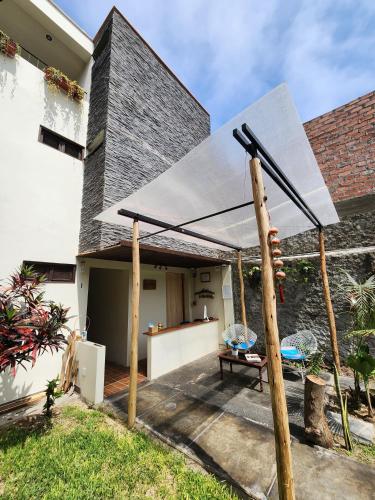 a patio with a white canopy in front of a house at China Chancay Hotel in Chancay