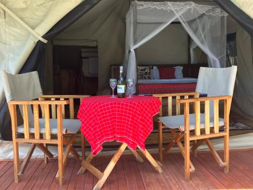 a table with two bottles of wine on it in a tent at Keremasi Camp Lake Natron in Mtowabaga