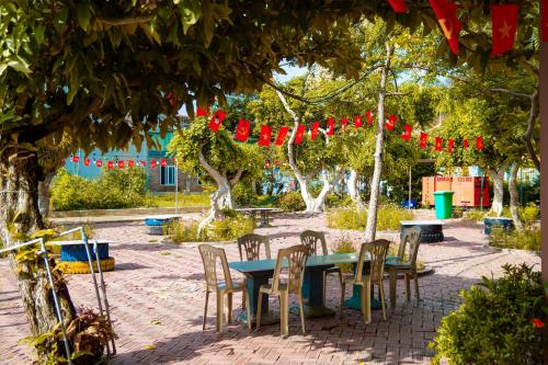 a table and chairs under a tree with red bows at Cô Tô Lương Chi in Quang Ninh