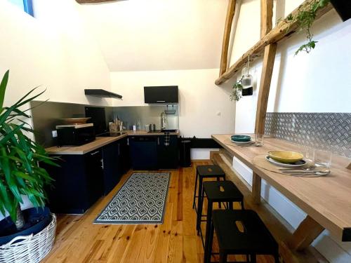 - une cuisine avec un comptoir et quelques chaises dans l'établissement La Maison Plutôt Gris-Bleu, à Estréelles