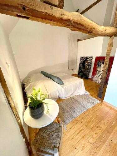 une petite pièce avec un lit et une table dans l'établissement La Maison Plutôt Gris-Bleu, à Estréelles