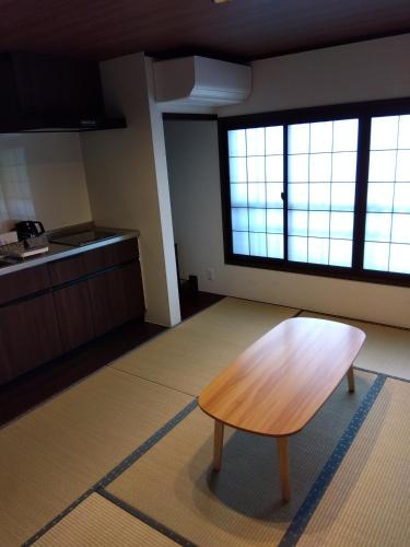 a kitchen with a wooden table in a room at Daihachi in Takayama