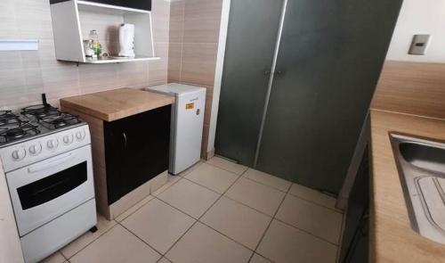 Departamento في كوتشابامبا: مطبخ صغير مزود بموقد وثلاجة