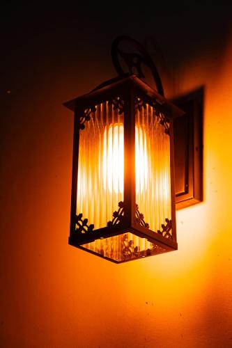 a lantern hanging on a wall with the light on at Kardi Residence By Bali Cabin in Cemagi