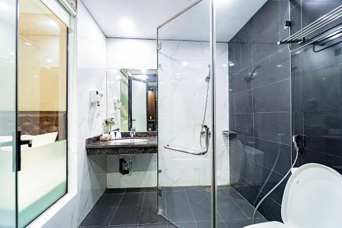 a bathroom with a glass shower and a toilet at MELANTA HOTEL FLC SẦM SƠN in Sầm Sơn