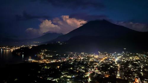 a view of a city at night with a mountain at Hotel Minnesota y Centro de Eventos Molina in San Lucas Tolimán