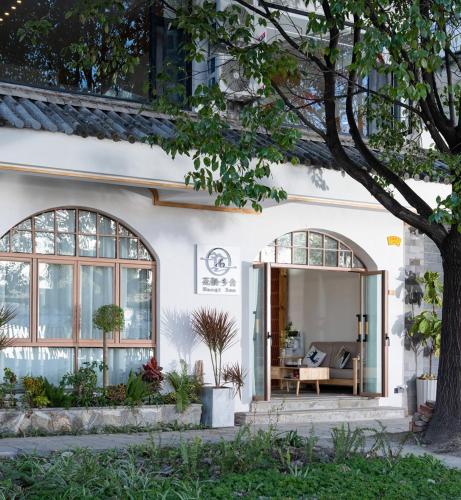 Dali ShuanglangにあるHuaqi Country House B&Bの大きな窓のある白い家