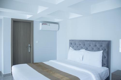 a bedroom with a large bed with white sheets and pillows at Parc21 Luxury Boutique Hotel in Phnom Penh
