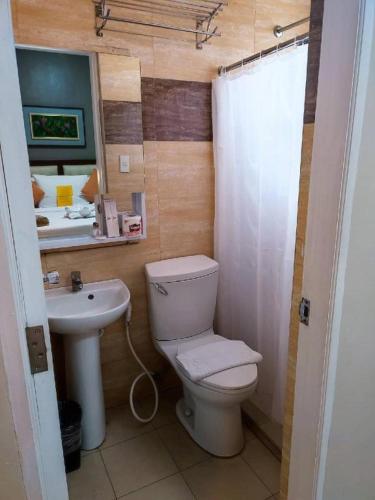 a bathroom with a toilet and a sink at Devera Hotel in Angeles