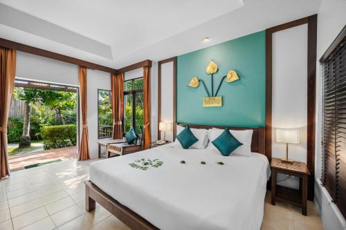 a bedroom with a large bed with a blue wall at Baan Chaweng Beach Resort & Spa - SHA Extra Plus in Chaweng