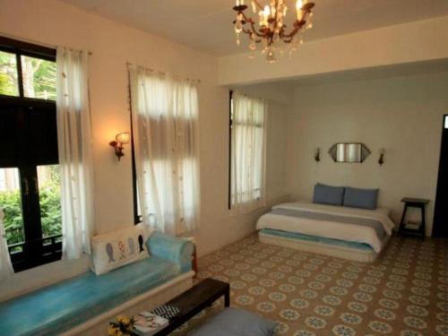 a bedroom with a bed and a chandelier at Brassiere Beach Hotel in Baanphakrimlay 