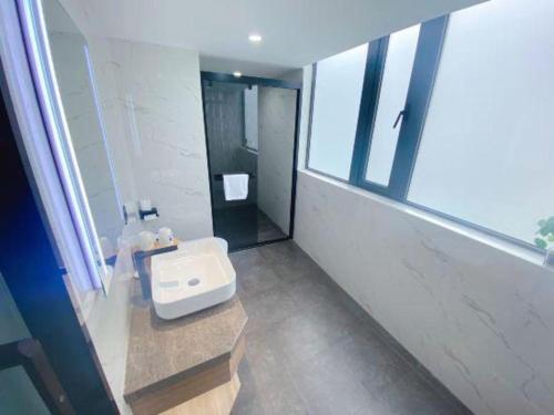 a bathroom with a white sink and a window at Super 8 Hotel Xiamen Railway Station in Xiamen
