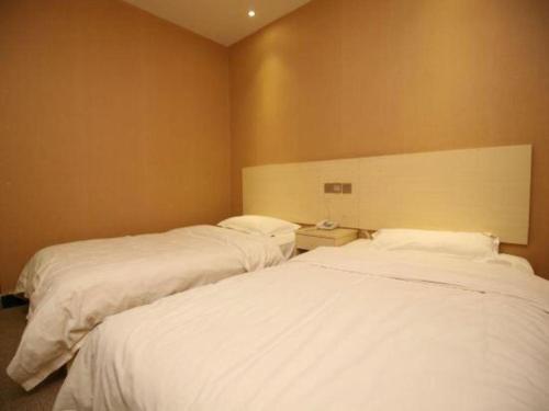 Postel nebo postele na pokoji v ubytování Kunming Tong Yi Business Hotel