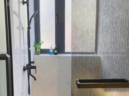a shower with a glass door with a window at Super 8 Hotel Xiamen Railway Station in Xiamen