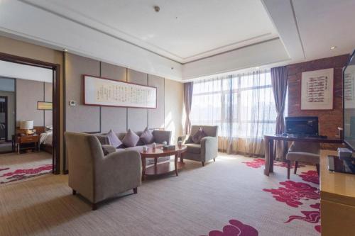 a living room with a couch and a table at The Prosperous City Hotel Weifang in Weifang