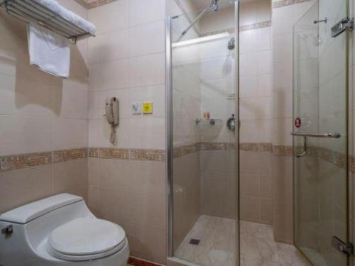 a bathroom with a toilet and a glass shower at Quanzhou Royal Prince Hotel in Quanzhou