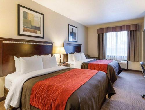 a hotel room with two beds and a window at Comfort Inn & Suites in Winnie