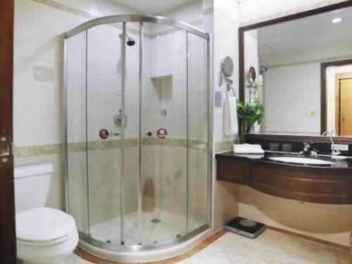 a bathroom with a shower and a toilet and a sink at Quanzhou Royal Prince Hotel in Quanzhou