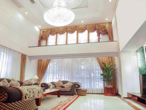 a living room with couches and a large window at Quanzhou Royal Prince Hotel in Quanzhou