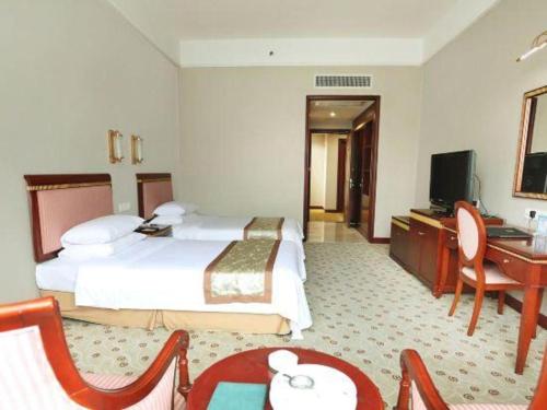 a hotel room with a bed and a desk and a television at Quanzhou Royal Prince Hotel in Quanzhou