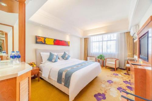 a hotel room with a bed and a television at Lijiang Waika Hotel in Lijiang