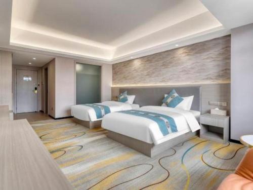 a hotel room with two beds and avisor at Lijiang Waika Hotel in Lijiang