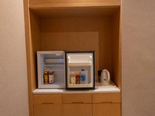 a small refrigerator with its door open in a kitchen at Lijiang Waika Hotel in Lijiang